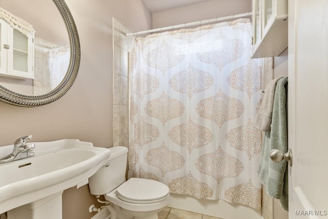 full bath featuring toilet, a shower with curtain, a sink, and tile patterned flooring