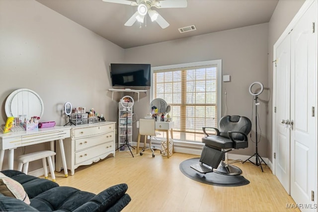 interior space with a ceiling fan, light wood finished floors, and visible vents