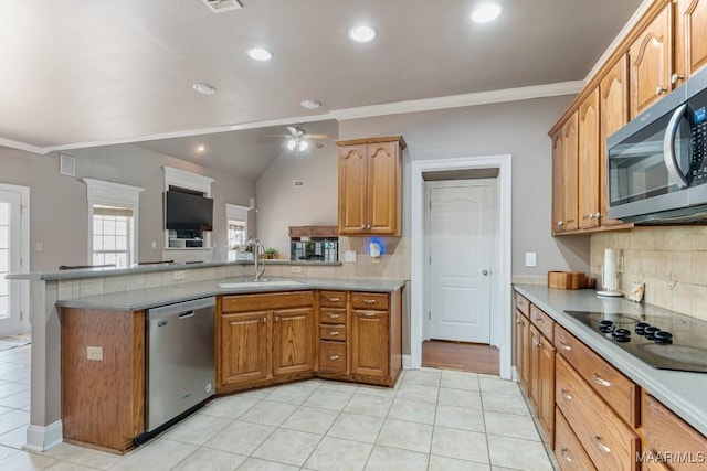 kitchen with decorative backsplash, a sink, a peninsula, ornamental molding, and stainless steel appliances