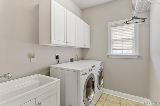 laundry room featuring washing machine and dryer, baseboards, a sink, cabinet space, and light tile patterned floors