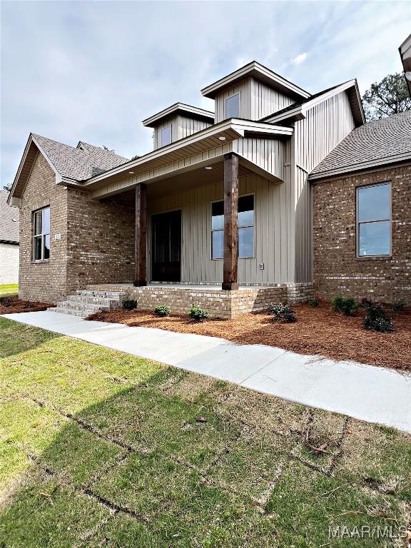 228 Mountain Laurel Rdg, Wetumpka, AL 36093 - view of front of property featuring board and batten siding, brick siding, and a front lawn