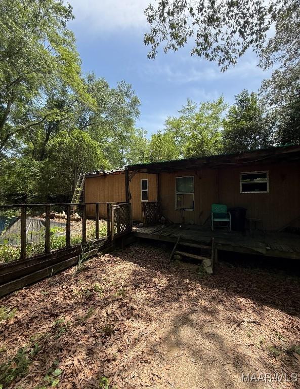 back of house with fence and a deck
