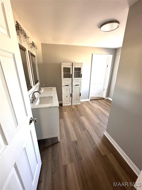 bathroom featuring wood finished floors, vanity, and baseboards