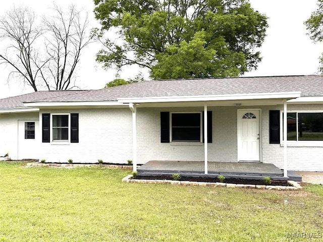 ranch-style house with a front yard, brick siding, a shingled roof, and covered porch