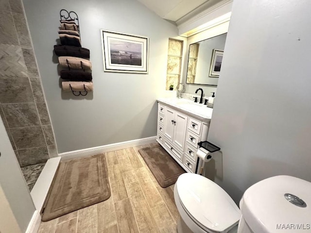2714 County Road 54, Ozark, AL 36360 - full bathroom with baseboards, toilet, a tile shower, wood finished floors, and vanity