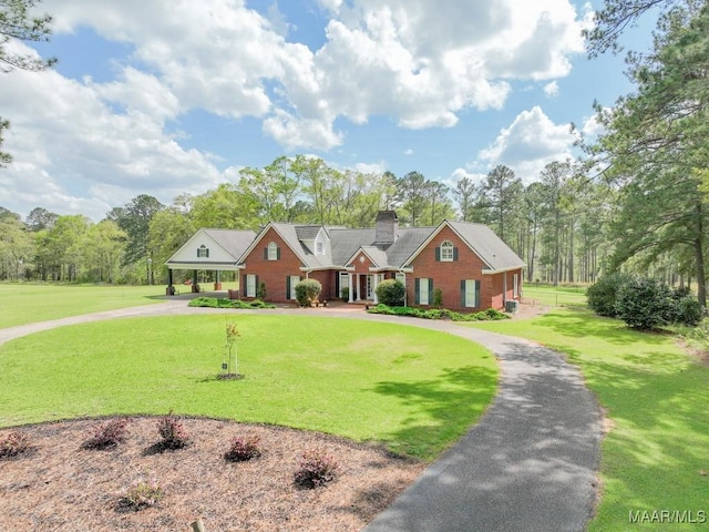 2714 County Road 54, Ozark, AL 36360 - view of front of home with brick siding, a front yard, curved driveway, and a chimney