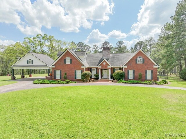 2714 County Road 54, Ozark, AL 36360 - view of front of home with curved driveway, a front lawn, brick siding, a carport, and a chimney