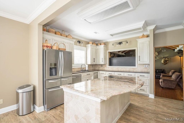 2714 County Road 54, Ozark, AL 36360 - kitchen featuring crown molding, appliances with stainless steel finishes, a sink, light wood-style floors, and a center island