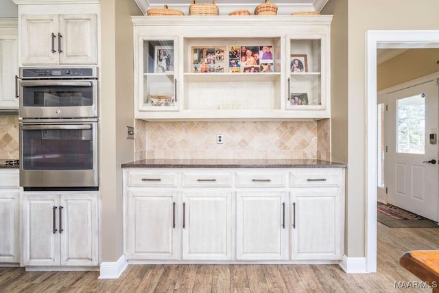 2714 County Road 54, Ozark, AL 36360 - kitchen featuring double oven, light wood-style flooring, and dark stone countertops