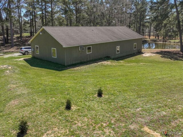 2714 County Road 54, Ozark, AL 36360 - view of side of home featuring a lawn, a water view, and roof with shingles
