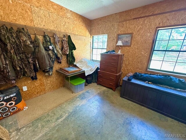 2714 County Road 54, Ozark, AL 36360 - bedroom featuring unfinished concrete flooring, multiple windows, and a textured ceiling