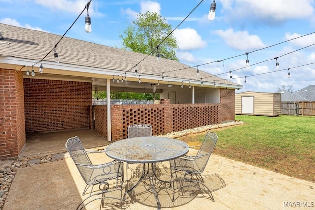 view of patio featuring an outbuilding, outdoor dining area, fence, and a shed