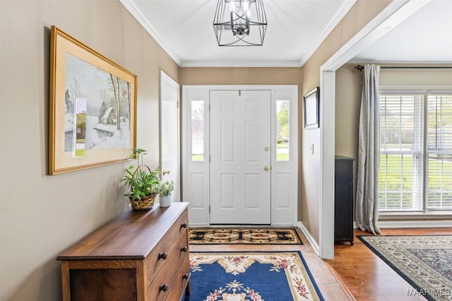 foyer entrance featuring ornamental molding, a notable chandelier, and light wood finished floors
