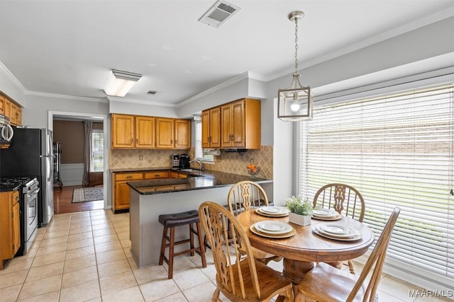 kitchen with crown molding, decorative backsplash, visible vents, a peninsula, and appliances with stainless steel finishes