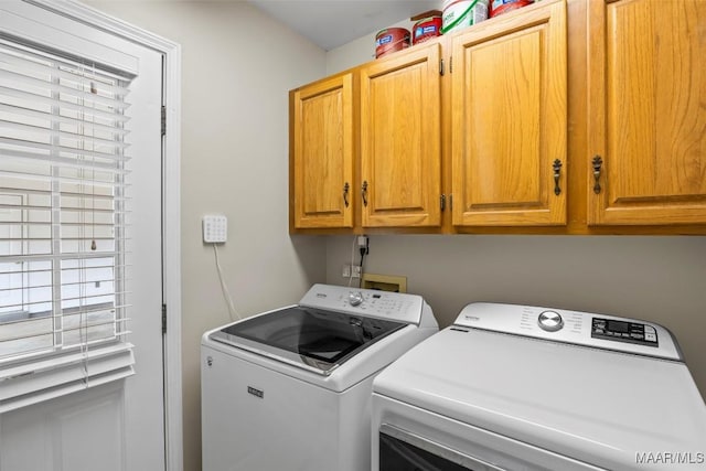 laundry area with washing machine and clothes dryer and cabinet space