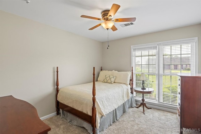 bedroom featuring baseboards, visible vents, a ceiling fan, and light colored carpet
