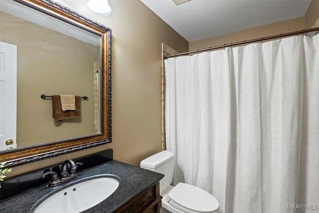 bathroom with visible vents, curtained shower, toilet, and vanity