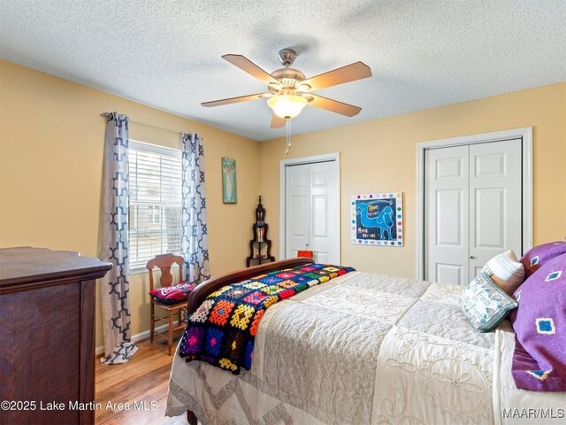 197 Maple Ridge Rd, Alexander City, AL 35010 - bedroom featuring a textured ceiling, two closets, baseboards, ceiling fan, and wood finished floors