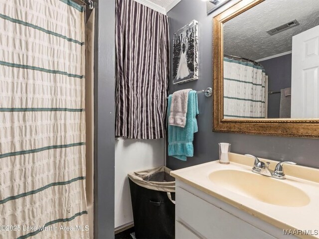 197 Maple Ridge Rd, Alexander City, AL 35010 - full bath featuring visible vents, crown molding, vanity, and a textured ceiling