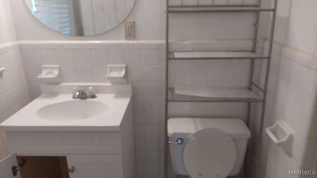 114 Dogwood Cir, Ozark, AL 36360 - half bathroom with tile walls, toilet, vanity, and a wainscoted wall