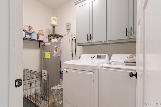washroom featuring washer and clothes dryer, cabinet space, and water heater