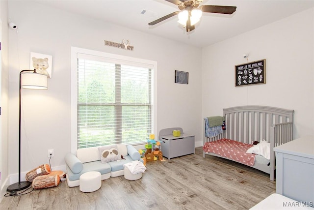 bedroom featuring wood finished floors, baseboards, and a ceiling fan