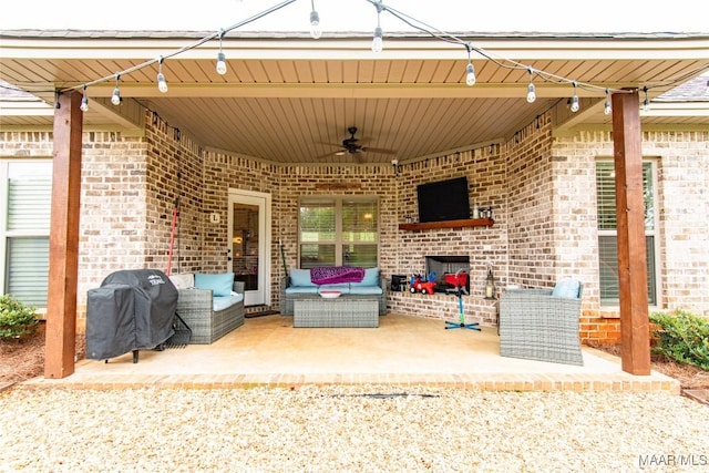 view of patio / terrace with area for grilling, an outdoor living space with a fireplace, and ceiling fan