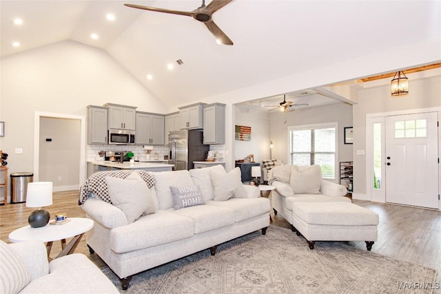 living area featuring ceiling fan, recessed lighting, light wood finished floors, high vaulted ceiling, and baseboards