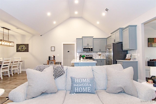 living room featuring recessed lighting, high vaulted ceiling, and wood finished floors