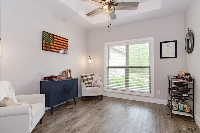 living area with wood finished floors, ceiling fan, and baseboards