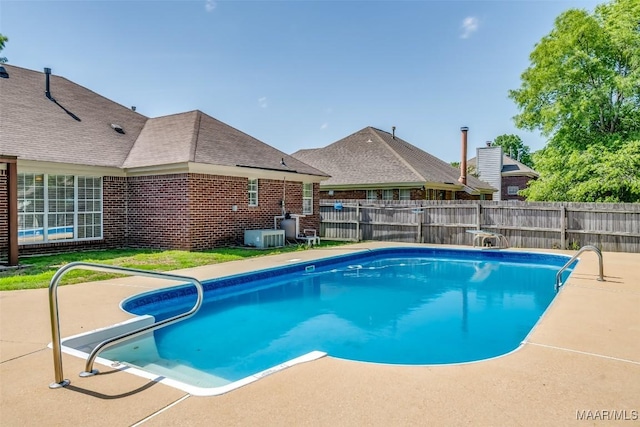view of swimming pool with fence, a patio, and central AC unit