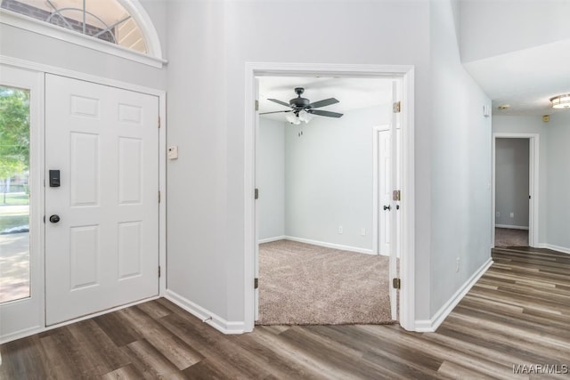 foyer with dark wood finished floors, baseboards, and a ceiling fan