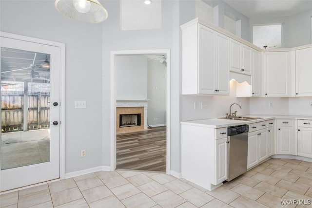kitchen with a sink, stainless steel dishwasher, a ceiling fan, and light countertops
