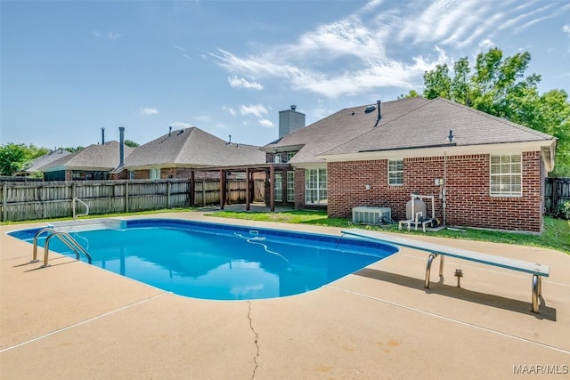 view of pool featuring a diving board, a patio area, and a fenced backyard