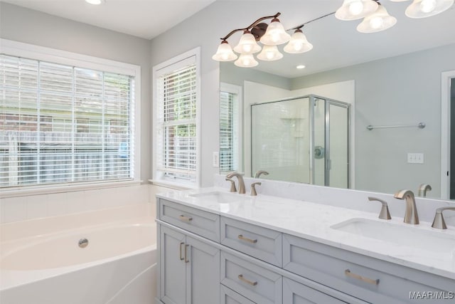 full bath featuring healthy amount of natural light, a shower stall, a bath, a chandelier, and recessed lighting