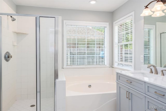 full bath with a bath, a stall shower, vanity, recessed lighting, and a chandelier