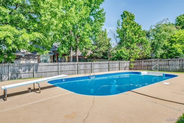 view of pool with a patio area, a diving board, and a fenced backyard