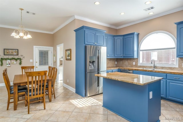 kitchen with a sink, light tile patterned floors, stainless steel fridge, and blue cabinets