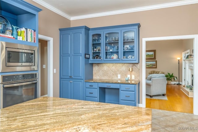 kitchen featuring backsplash, blue cabinets, ornamental molding, and stainless steel appliances