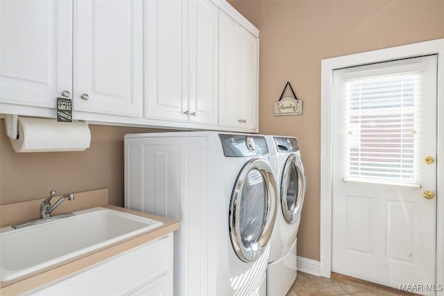 clothes washing area featuring a sink, light tile patterned floors, cabinet space, and separate washer and dryer