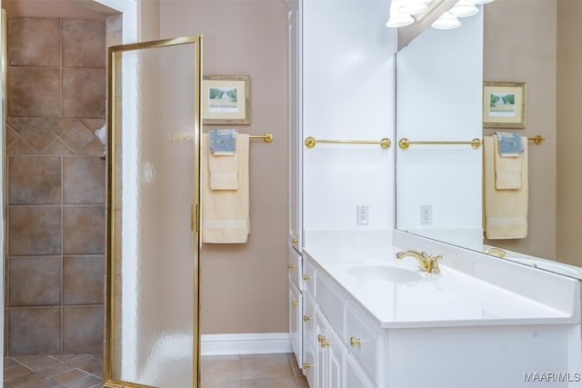 bathroom featuring a stall shower, vanity, baseboards, and tile patterned flooring