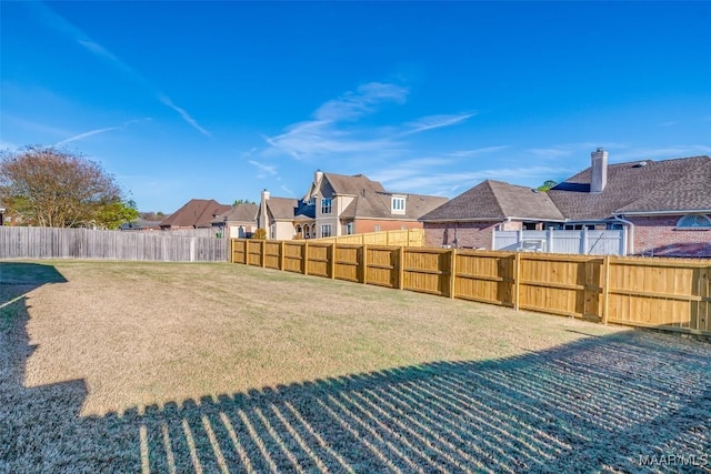 view of yard with a residential view and a fenced backyard