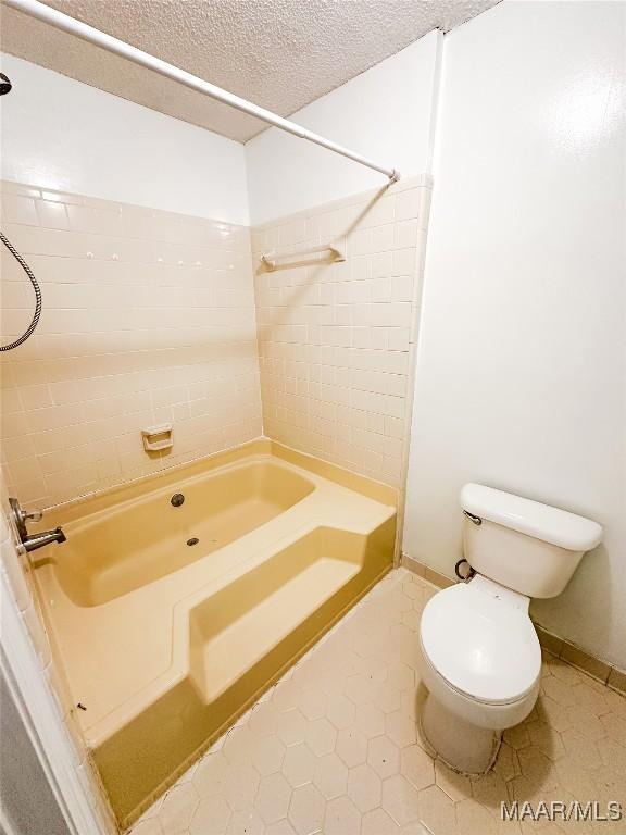 417 York Dr, Selma, AL 36701 - bathroom featuring tile patterned flooring, a textured ceiling, toilet, and bathing tub / shower combination