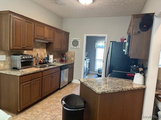 1518 White Cloud Dr, Deatsville, AL 36022 - kitchen with a toaster, backsplash, light stone countertops, stainless steel dishwasher, and a sink