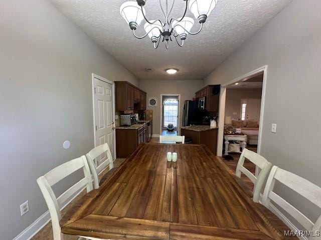 1518 White Cloud Dr, Deatsville, AL 36022 - dining room with a chandelier, a textured ceiling, and baseboards