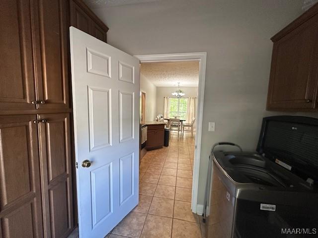 1518 White Cloud Dr, Deatsville, AL 36022 - laundry area featuring a chandelier, light tile patterned floors, cabinet space, and washing machine and dryer