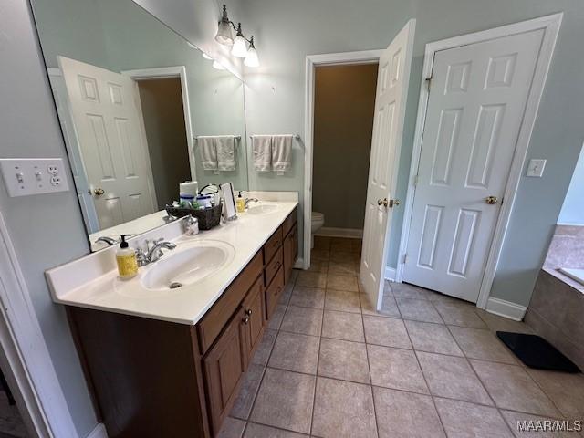 1518 White Cloud Dr, Deatsville, AL 36022 - bathroom featuring toilet, tile patterned floors, double vanity, and a sink