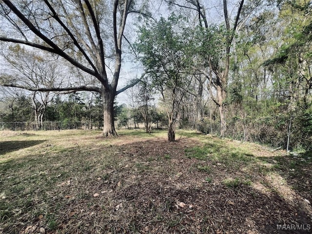 view of yard with a view of trees and fence