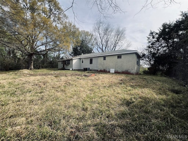 rear view of house featuring a yard and cooling unit