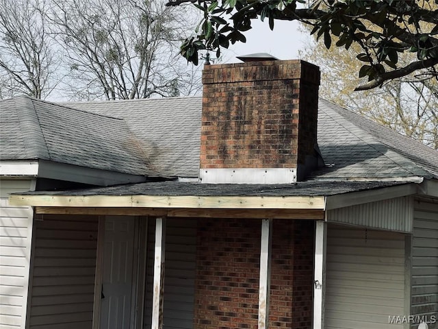 exterior details featuring brick siding, roof with shingles, and a chimney